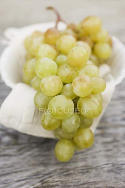 Green grapes in white bowl — Stock Photo