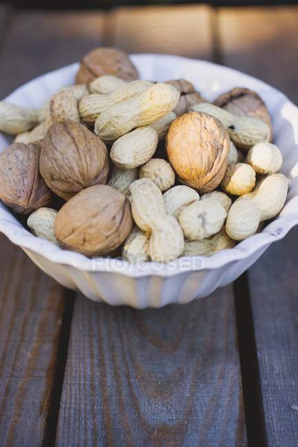 Nueces y cacahuetes en tazón - foto de stock