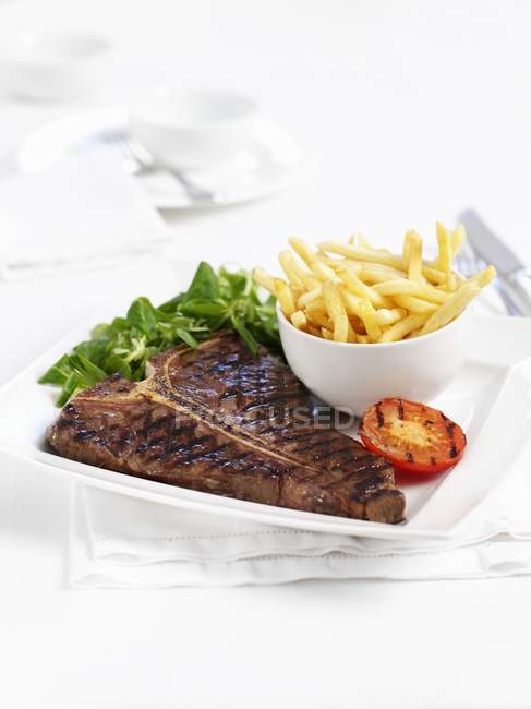 T-bone steak avec croustilles frites — Photo de stock