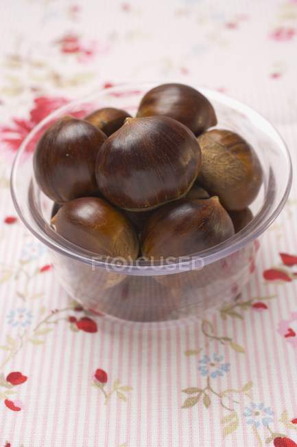 Several chestnuts in glass dish — Stock Photo