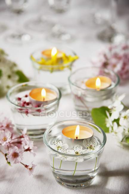 Vista elevada de la mesa decorada con flores y luces de té - foto de stock