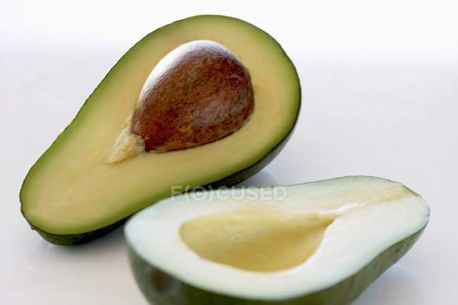 Halved avocado with stone — Stock Photo