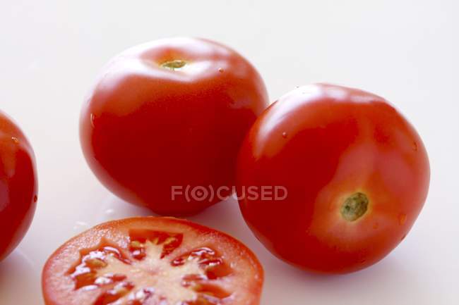 Tomates enteros y rebanadas - foto de stock