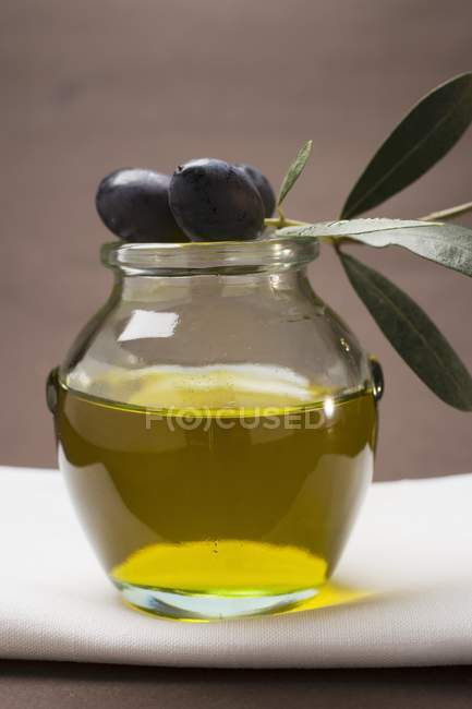 Black olives on jar of olive oil — Stock Photo