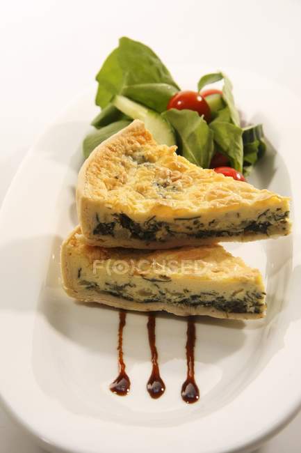 Spinach quiche with a side salad on white plate — Stock Photo