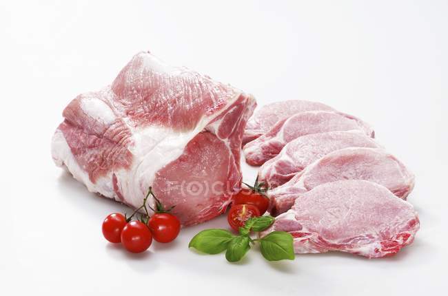 Raw piece of pork and individual chops — Stock Photo