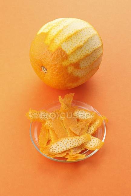 Свіжий апельсин і скибочки шкірки — стокове фото