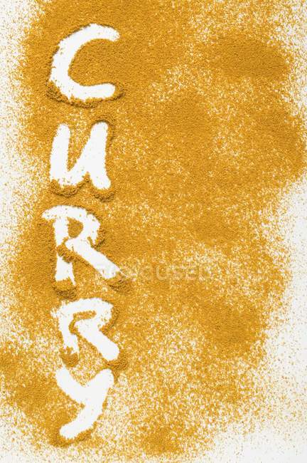 Palavra Curry escrito em pó de caril — Fotografia de Stock