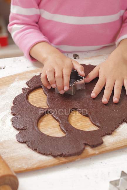 Nahaufnahme eines Kindes, das Kekse ausschneidet — Stockfoto