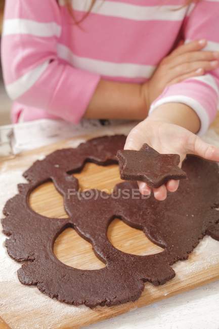 Closeup view of girl holding a cut-out star-shaped biscuit — Stock Photo