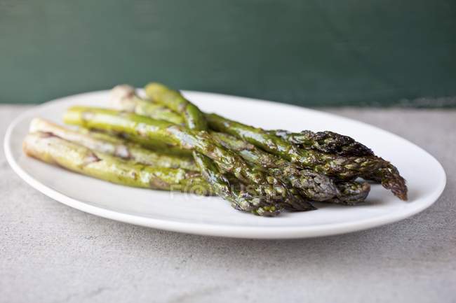 Asparagi arrosto su piatto bianco — Foto stock
