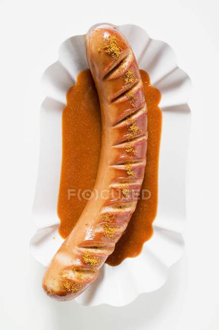 Salchicha Currywurst con ketchup y curry en polvo - foto de stock