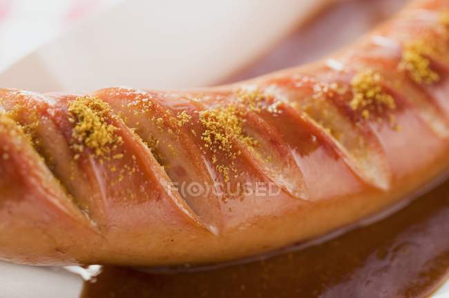 Sausage with ketchup and curry powder — Stock Photo