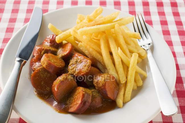 Embutidos currywurst con ketchup y curry en polvo - foto de stock