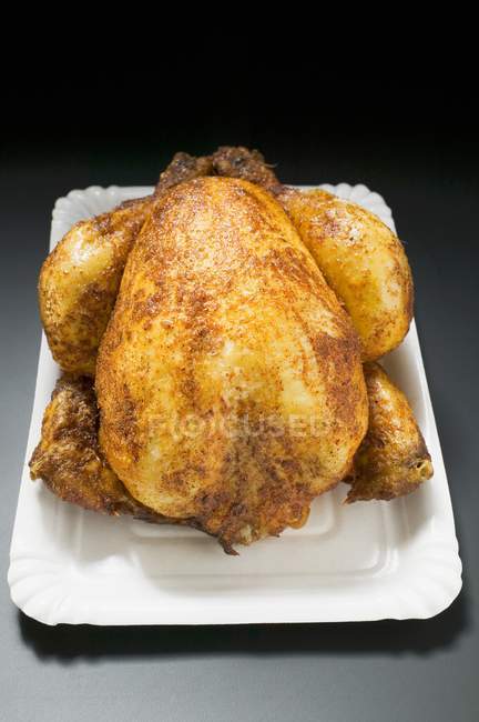 Pollo asado entero en plato de papel - foto de stock