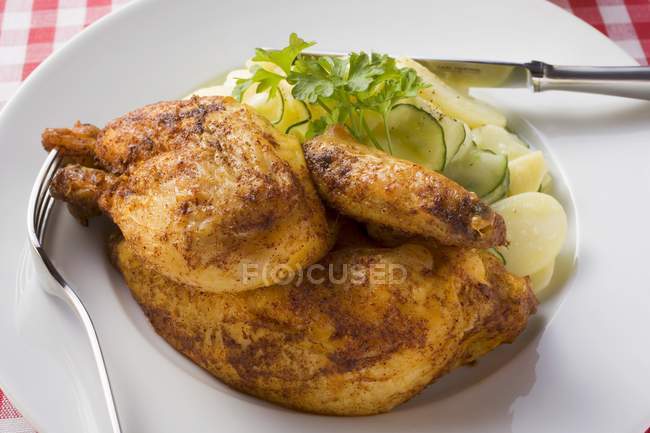 Pollo asado con ensalada de patata y pepino - foto de stock