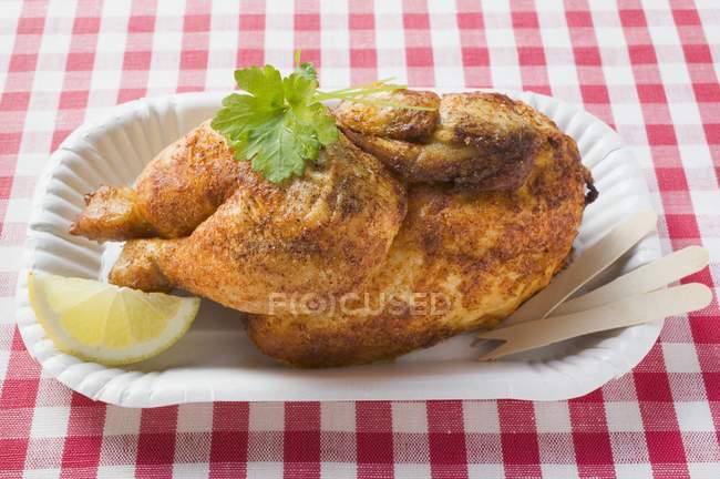 Half of roasted chicken in paper dish — Stock Photo