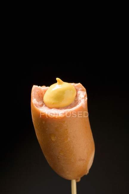 Frankfurter with mustard on cocktail stick — Stock Photo