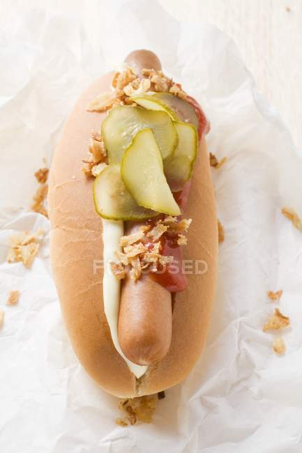 Hot dog with gherkin and ketchup — Stock Photo