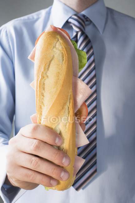 Hombre de negocios sosteniendo sándwich de jamón - foto de stock