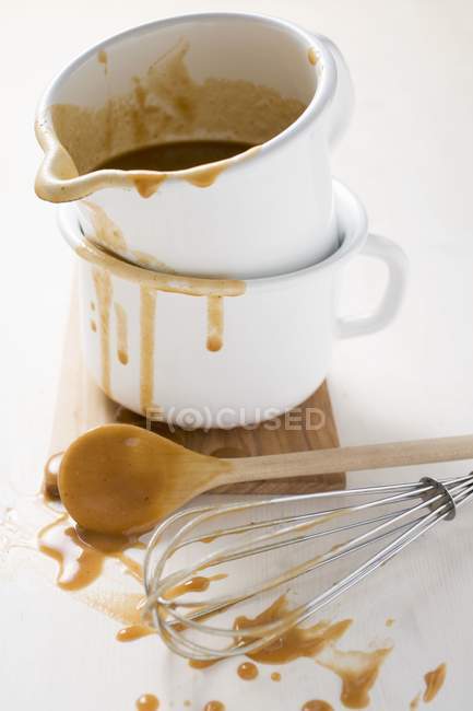Gravy in an enamel jug with whisk — Stock Photo