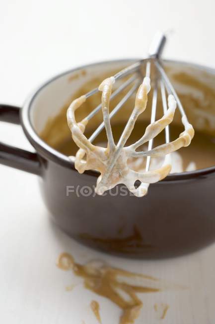 Frusta con creme fraiche appoggiata su tegame — Foto stock