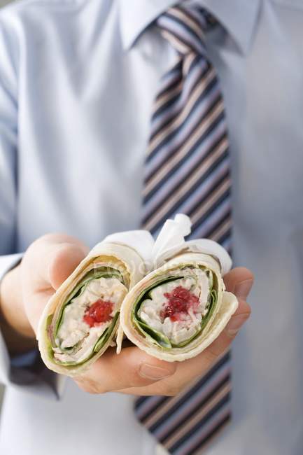 Closeup view of man in shirt and tie holding two wraps — Stock Photo