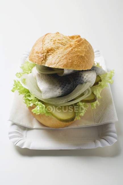 Herring with onions and gherkins in bread roll — Stock Photo