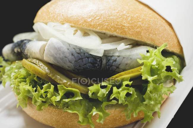 Herring with onions and gherkins in bread roll — Stock Photo