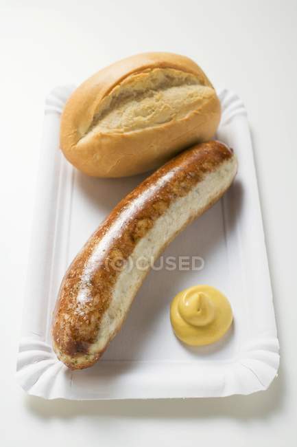 Sausage with mustard and baguette roll — Stock Photo