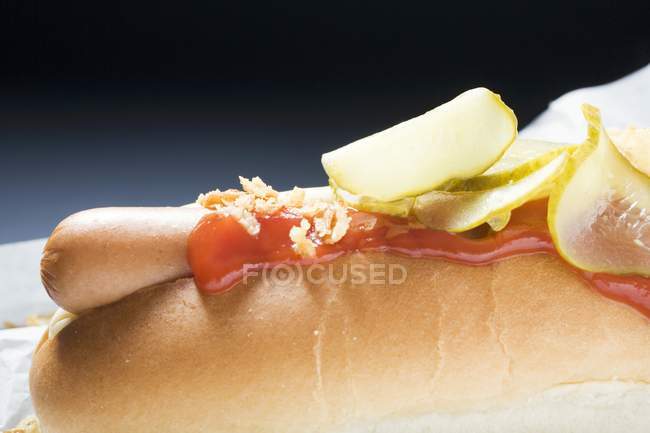 Cachorro quente com ketchup e pepinos — Fotografia de Stock