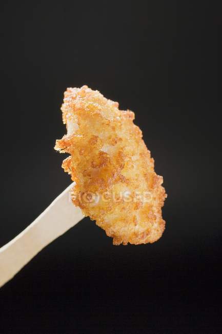 Closeup view of chicken nugget on a wooden fork — Stock Photo