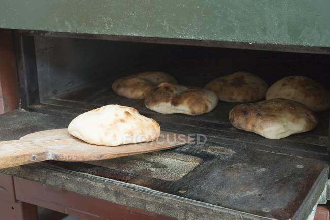Свежеиспеченный хлеб из питы на лопате — стоковое фото