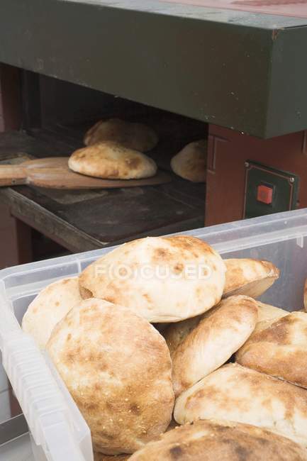 Pita bread in oven and in plastic crate — Stock Photo