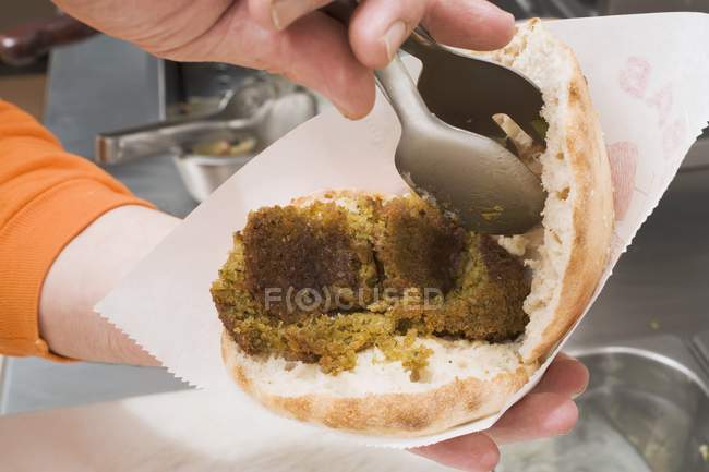 Garnishing pita with falafel balls — Stock Photo