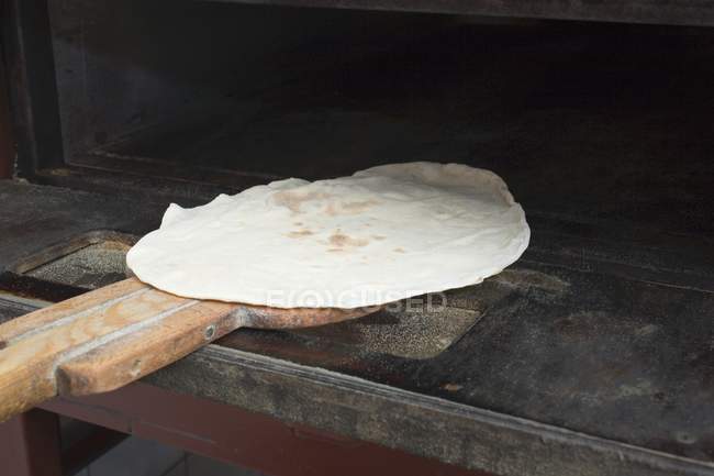 Flatbread in oven on server — Stock Photo