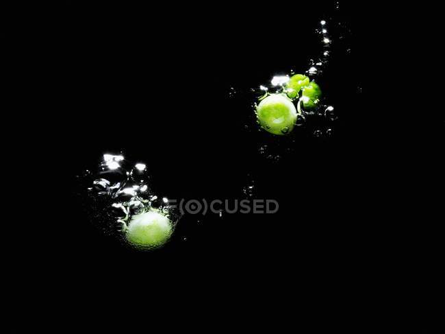 Свежий зеленый горошек в воде — стоковое фото