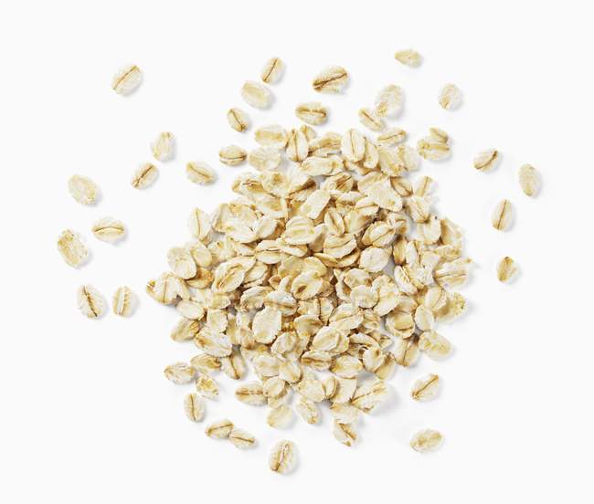 Closeup top view of oats heap on white surface — Stock Photo