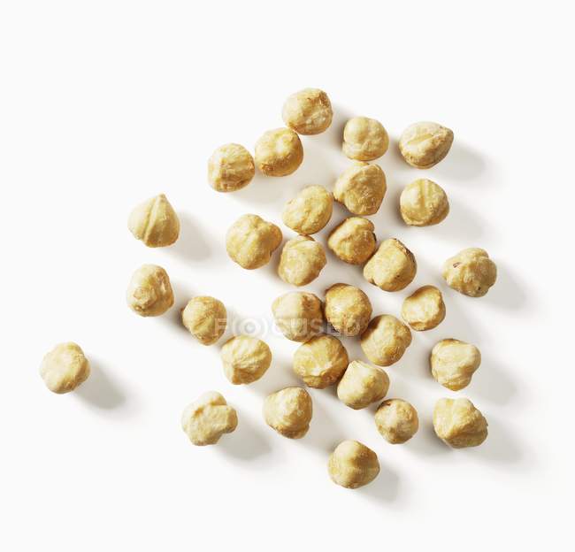 Caramelised hazelnuts on white — Stock Photo