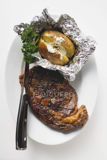 Bife grelhado com batata assada — Fotografia de Stock