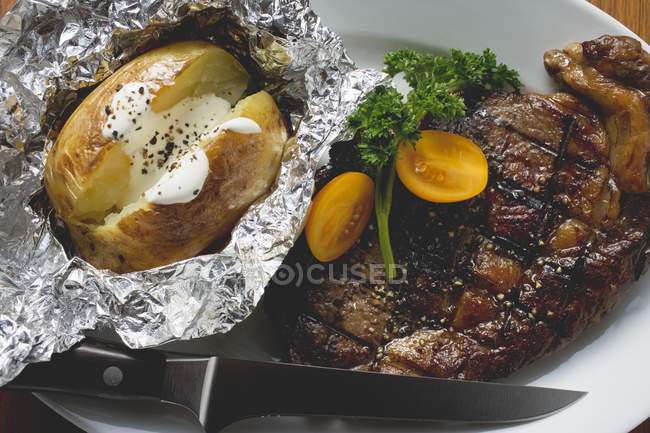 Стейк на гриле из говядины с печеной картошкой — стоковое фото