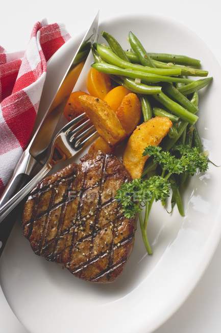 Steak de bœuf grillé avec quartiers de pommes de terre — Photo de stock