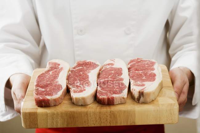 Chef holding sirloin steaks — Stock Photo