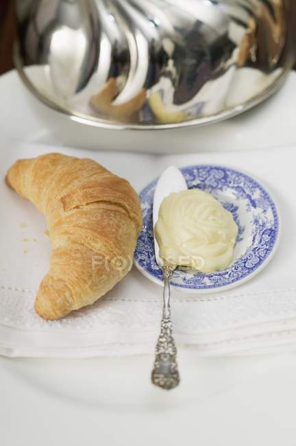Croissant près de plaque de beurre — Photo de stock