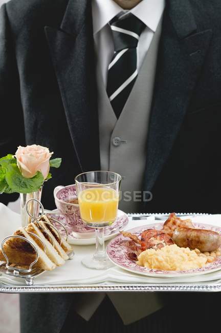 Butler servant le petit déjeuner anglais sur plateau — Photo de stock