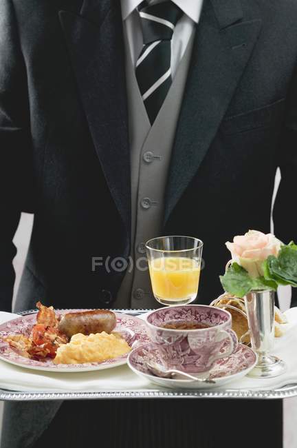 Maggiordomo che serve colazione inglese su vassoio — Foto stock