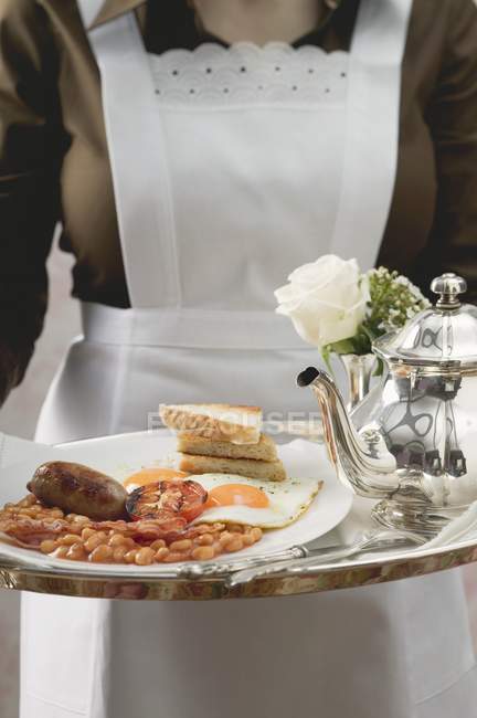 Zimmermädchen serviert englisches Frühstück auf Tablett — Stockfoto