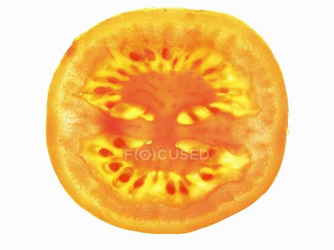 Rebanada de tomate con retroiluminación - foto de stock