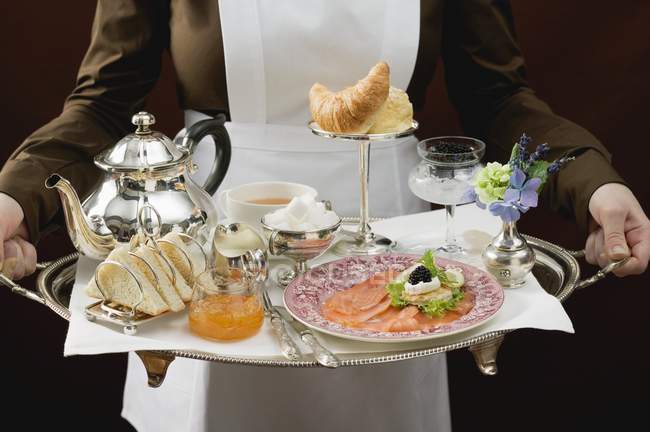 Vista cortada de camareira que serve bandeja de pequeno-almoço de luxo — Fotografia de Stock