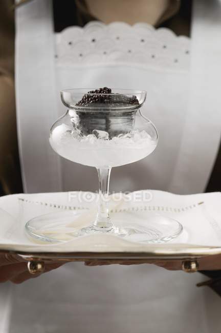 Vue rapprochée de la femme de chambre servant du caviar en verre à tige sur plateau — Photo de stock